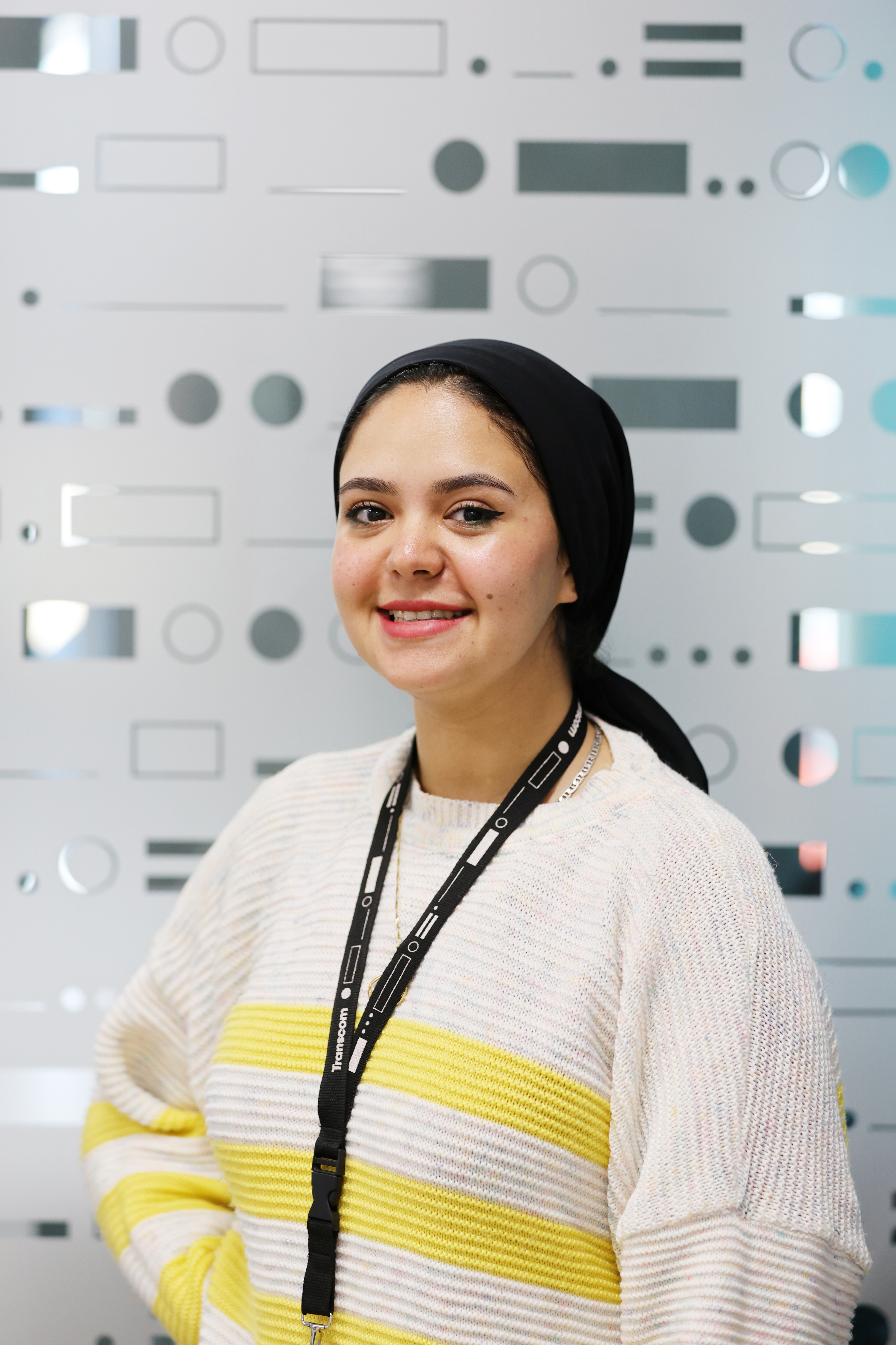 Smiling woman in a hijab with a lanyard