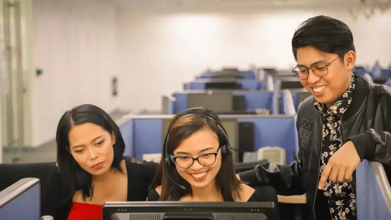 Three people looking at moniter