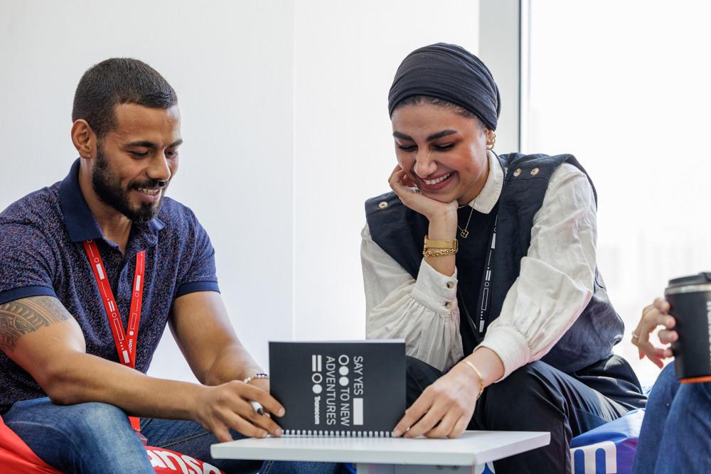 Two colleagues smiling and discussing ideas during a casual meeting